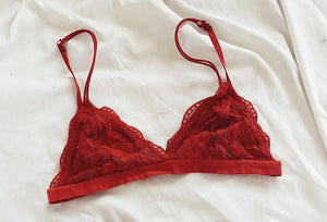 Red lace triangle bralette from NKD on white bed sheets